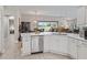 Modern kitchen with stainless steel appliances and white countertops open to a dining area at 1266 James Island St, The Villages, FL 32162
