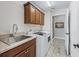 Well-equipped laundry room with sink, ample cabinetry, and modern washer and dryer at 1266 James Island St, The Villages, FL 32162