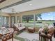Bright sunroom with golf course views, featuring large windows and comfortable seating at 1266 James Island St, The Villages, FL 32162