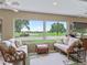 Bright sunroom with golf course views, featuring large windows and comfortable seating at 1266 James Island St, The Villages, FL 32162