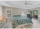 Bright main bedroom boasts tray ceiling, light wood floors, and sliding glass doors to lanai at 1266 James Island St, The Villages, FL 32162