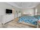 Bright bedroom has wood floors, tray ceiling, and white dressers with storage at 1266 James Island St, The Villages, FL 32162