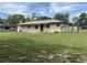 Backyard view showing a large grassy area, outbuildings, and fencing at 145 Ne 71St Ave, Ocala, FL 34470