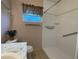 Bathroom featuring shower with safety bars, window, toilet, and sink with vanity at 145 Ne 71St Ave, Ocala, FL 34470