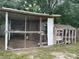 Backyard features a rustic chicken coop with wire mesh and wooden construction at 145 Ne 71St Ave, Ocala, FL 34470