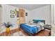 Bright bedroom with a comfortable bed, wood-look floors, and window with curtains at 14762 Sw 22Nd Court Rd, Ocala, FL 34473