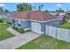 Side angled view of the home displaying the light blue exterior paint, the driveway, and the attached one car garage at 14762 Sw 22Nd Court Rd, Ocala, FL 34473
