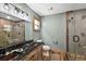 Modern bathroom features a granite countertop, dual copper sinks, and a wood-look tiled shower at 15360 Se 73Rd Avenue, Summerfield, FL 34491