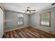 Comfortable bedroom with a ceiling fan, wood-look floors, and natural light from dual windows at 15360 Se 73Rd Avenue, Summerfield, FL 34491