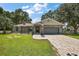 Charming single-story home featuring a stone-accented facade, paver driveway, and beautifully landscaped front yard at 15360 Se 73Rd Avenue, Summerfield, FL 34491