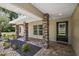 Inviting covered front porch with stone columns and decorative landscaping, offering a warm welcome at 15360 Se 73Rd Avenue, Summerfield, FL 34491
