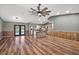 Open-concept living area featuring wood-look floors, wood trim and a view of the patio and pool at 15360 Se 73Rd Avenue, Summerfield, FL 34491