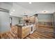Open concept living area and kitchen with wood floors, a fireplace and brick-clad island at 15360 Se 73Rd Avenue, Summerfield, FL 34491