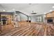 Open-concept living space with wood floors, brick fireplace, kitchen island, and natural light at 15360 Se 73Rd Avenue, Summerfield, FL 34491