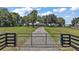 Gated entry leads to home with a long drive, large yard and outbuildings at 15360 Se 73Rd Avenue, Summerfield, FL 34491