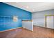 Office room with hardwood flooring, blue accent wall and a door to the interior at 15360 Se 73Rd Avenue, Summerfield, FL 34491