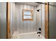 Close up of bathtub and shower, featuring wood-look trim and metallic siding at 15360 Se 73Rd Avenue, Summerfield, FL 34491