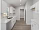 Well-lit kitchen boasts bright white cabinets, stainless steel hardware, and modern wood-look flooring at 15369 Sw 38Th Pl, Ocala, FL 34481