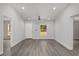 Open-concept living space with new gray flooring, recessed lighting, and freshly painted white walls at 15369 Sw 38Th Pl, Ocala, FL 34481