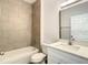 The bathroom features modern tile, white cabinets, and a bathtub and shower combination at 1686 Sw 168Th Loop, Ocala, FL 34473