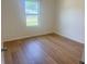 Bright bedroom featuring wood-look floors and a window letting in natural light at 1686 Sw 168Th Loop, Ocala, FL 34473