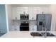 Well-equipped kitchen with stainless steel appliances, white cabinetry, and a kitchen island at 1686 Sw 168Th Loop, Ocala, FL 34473