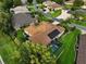 An aerial view shows a landscaped property with a screened pool and solar panels on the roof at 1953 Hartford Path, The Villages, FL 32162