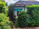 Backyard view showcasing a screened-in lanai amidst lush landscaping, providing a private outdoor living space at 1953 Hartford Path, The Villages, FL 32162