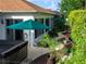 Landscaped backyard with a hot tub, a green umbrella, and a walkway leading to a seating area at 1953 Hartford Path, The Villages, FL 32162