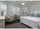 Well-lit bedroom featuring plantation shutters, hardwood floors, and comfortable seating for a relaxing and welcoming space at 1953 Hartford Path, The Villages, FL 32162