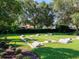 Bocce ball courts surrounded by manicured lawns and mature trees in a serene community setting at 1953 Hartford Path, The Villages, FL 32162