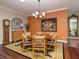 Formal dining room features a stylish chandelier, dark hardwood floors, and space for entertaining guests at 1953 Hartford Path, The Villages, FL 32162
