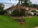 Wide angle of the home's exterior with mature trees and manicured landscaping at 1953 Hartford Path, The Villages, FL 32162