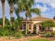 Beautiful home exterior with lush landscaping, palm trees, stone accents, and a welcoming entrance at 1953 Hartford Path, The Villages, FL 32162