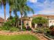 Charming home featuring lush landscaping, colorful flowers, and a stone accented facade at 1953 Hartford Path, The Villages, FL 32162