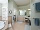 A spacious main bathroom with a double sink vanity, bathtub, tiled floors, and separate toilet area at 1953 Hartford Path, The Villages, FL 32162