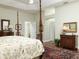 A primary bedroom features a four poster bed, tray ceilings, and access to other rooms at 1953 Hartford Path, The Villages, FL 32162