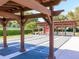 Community shuffleboard courts under wooden pergolas amid lush landscaping, perfect for outdoor recreation at 1953 Hartford Path, The Villages, FL 32162