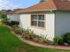 Well-maintained side yard featuring lush landscaping, decorative rock beds, and a view of the home's exterior at 1953 Hartford Path, The Villages, FL 32162