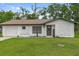Charming single-story home features a welcoming facade, attached garage and a well-manicured lawn at 21191 Sw Plantation St, Dunnellon, FL 34431