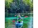 Two individuals paddling in kayaks through crystal-clear river waters at 21191 Sw Plantation St, Dunnellon, FL 34431