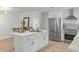 Modern kitchen features stainless appliances, quartz countertops, and an island with seating at 21191 Sw Plantation St, Dunnellon, FL 34431