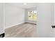 Bright bedroom with vinyl floors, fresh paint, baseboard trim, and natural light from the window at 2297 Sw 143 Ct, Ocala, FL 34481
