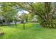 Serene backyard featuring a tree swing, lush green grass, mature tree and secure fence, creating a perfect play area at 2640 Sw 36Th Ln, Ocala, FL 34471