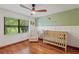 Bedroom featuring hardwood floors, a crib, chair and large window at 2640 Sw 36Th Ln, Ocala, FL 34471
