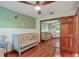 Charming Bedroom featuring hardwood floors, a crib, closet and ceiling fan at 2640 Sw 36Th Ln, Ocala, FL 34471
