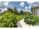 Landscaped front yard with mature trees, bushes, and a winding sidewalk, inviting curb appeal at 2640 Sw 36Th Ln, Ocala, FL 34471