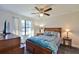 Cozy bedroom featuring a wood-framed bed, ceiling fan, and ample natural light from the window at 2855 Se 38Th St, Ocala, FL 34480