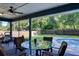 Relaxing screened patio with comfortable seating and view of the lush backyard and pool at 2855 Se 38Th St, Ocala, FL 34480