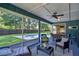 Spacious screened patio with seating, dining area, and view of the sparkling pool and lawn at 2855 Se 38Th St, Ocala, FL 34480
